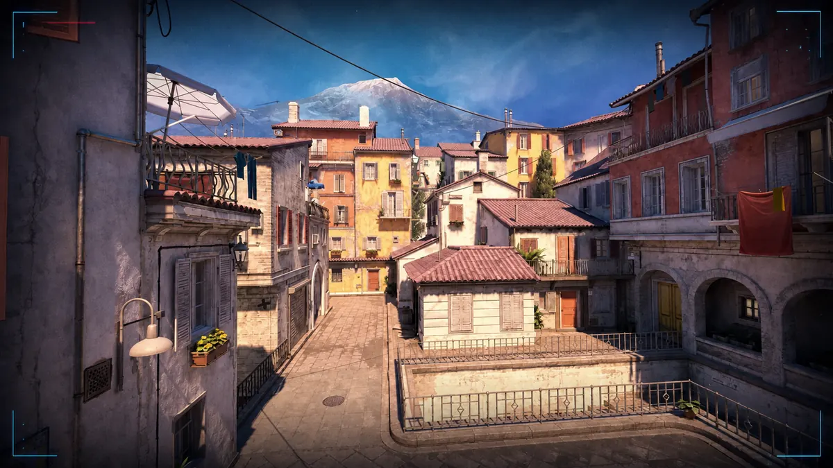 Inferno street and colorful buildings in Counter-Strike 2 under a broadcast-style editorial frame